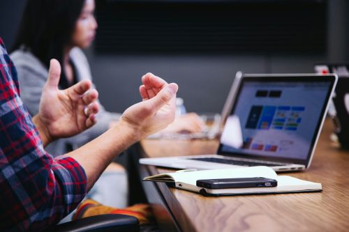 man with laptop gesturing